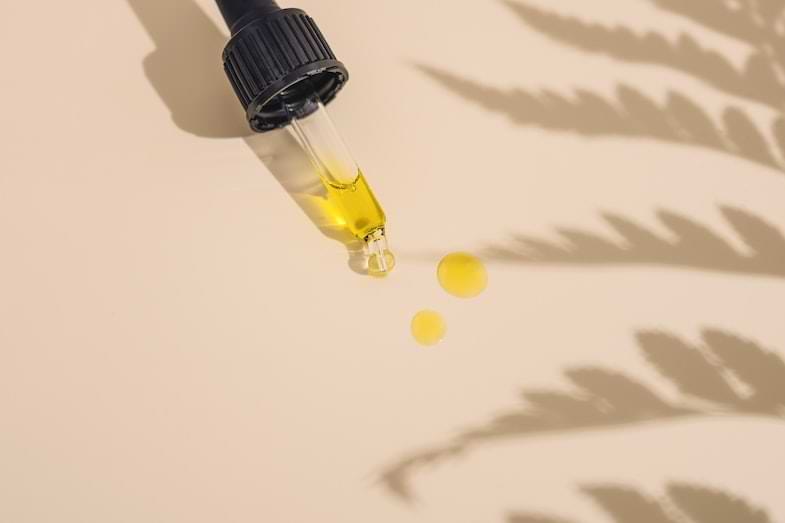 Botella de aceite de CBD con pipeta sobre fondo claro