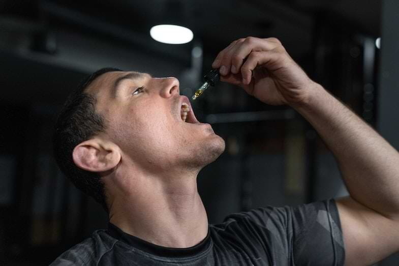 Frasco cuentagotas de aceite de CBD ambar sobre una superficie limpia