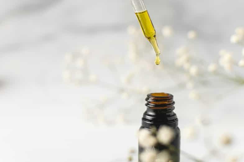 Frasco de aceite de CBD ambar sobre una superficie clara